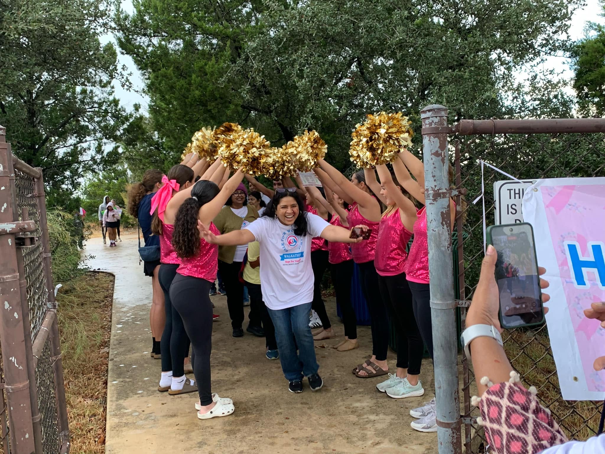 A Hope For Triumph volunteer walking through a cheer tunnel at the Walk Your Worries Away Walkathon